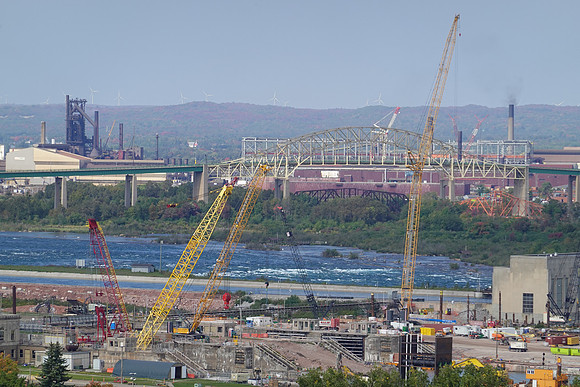 Reconstruction of the new locks in forefront.  St. Mary's River rapids in middle.  Canada in the background.